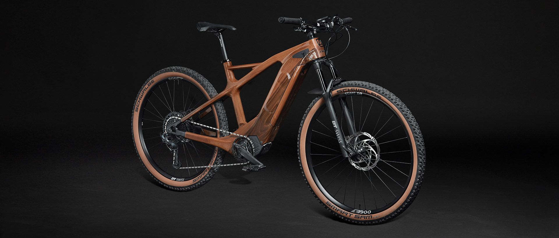 e-ANNUM wooden electric mountain bicycle against a dark background